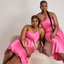 two models wearing a pink satin dress